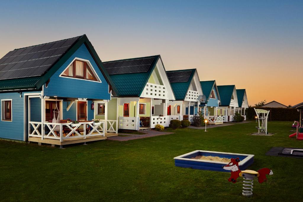 a row of houses with a pool in the yard at Morska Mila in Gąski