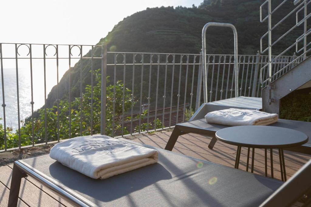a balcony with two pillows and a table and a view of the ocean at The Sunset Line in Riomaggiore