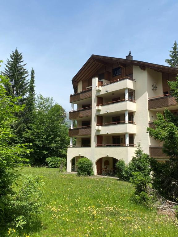 an apartment building with a grassy field in front of it at Ferienwohnung Runca in Flims