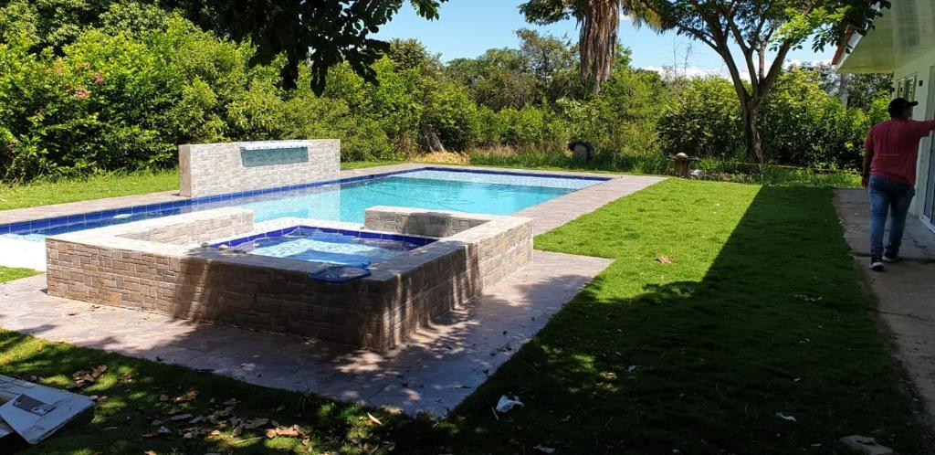a swimming pool in a yard next to a house at Villa Gabriela in Agua de Dios