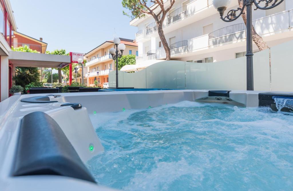 a jacuzzi in a swimming pool next to a building at Hotel Nobel in Rimini