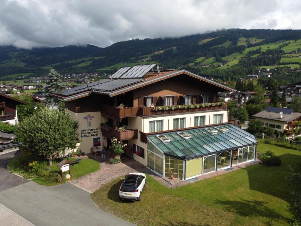 dom z samochodem zaparkowanym przed nim w obiekcie Wellness Pension Hollaus w mieście Kirchberg in Tirol