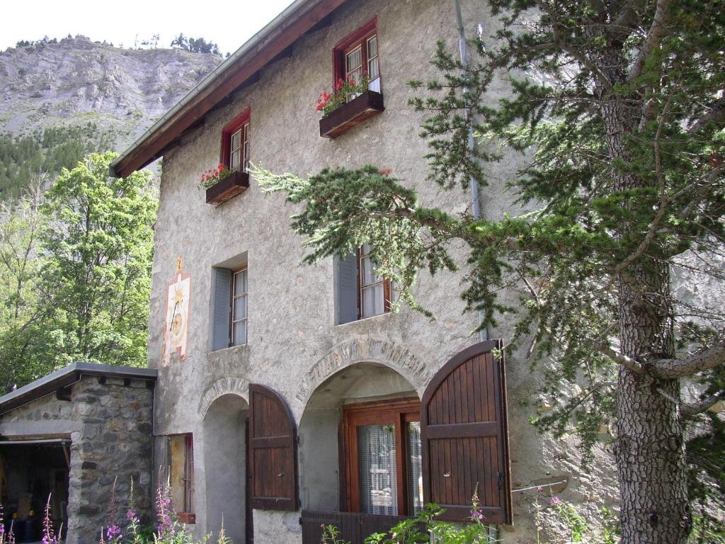 a stone house with wooden doors and windows at Le Pont de l' Alp in Le Monêtier-les-Bains