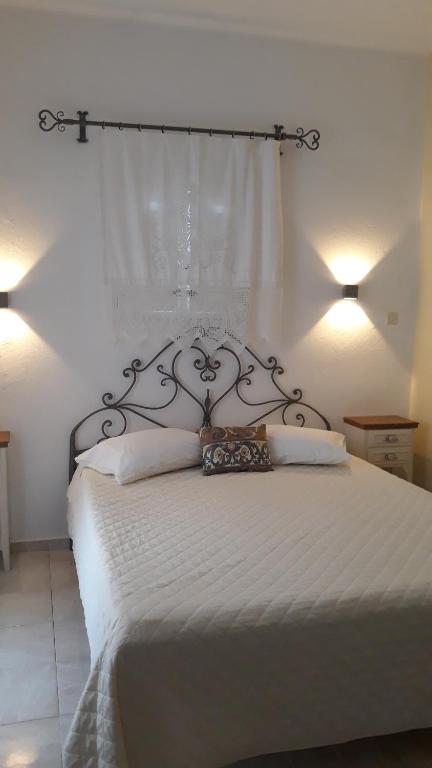 a bedroom with a white bed with a metal headboard at Pension Barbara in Katapola