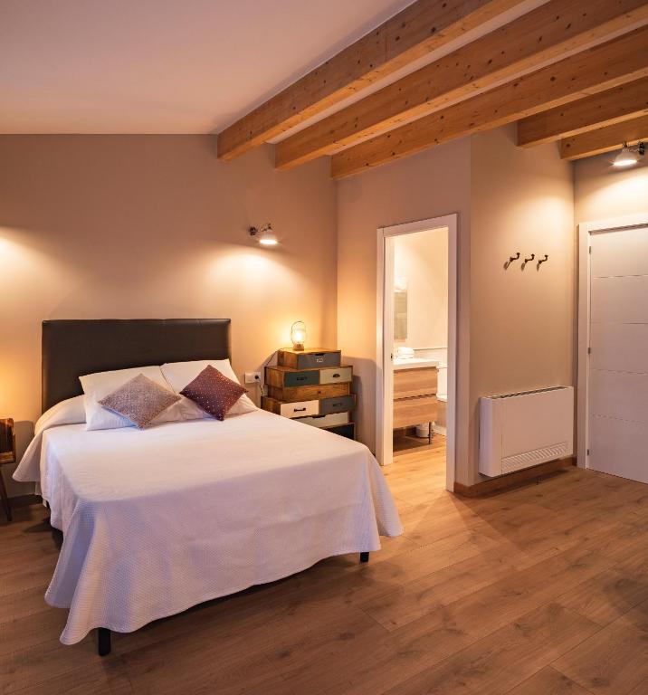 a bedroom with a large white bed and a bathroom at PassiveRooms in Vilanova i la Geltrú