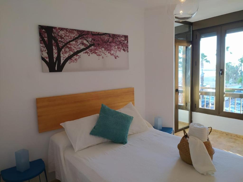 a bedroom with a white bed with a tree picture on the wall at Sunbeach Malagueta in Málaga