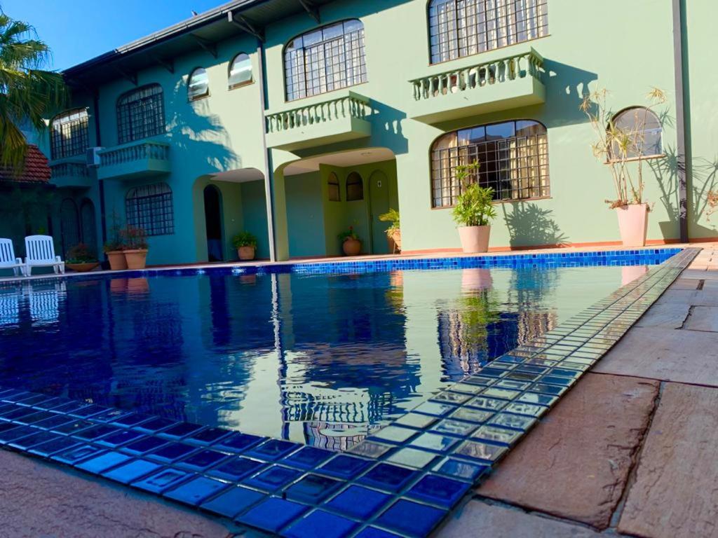 a house with a swimming pool in front of a house at Vila Verde Hotel in Toledo