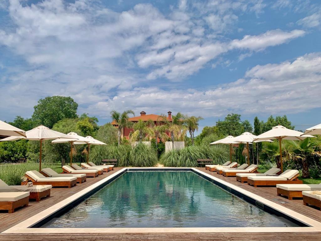 una piscina con tumbonas y sombrillas en Santa Lucia Maccarese - Residenza Agricola en Maccarese