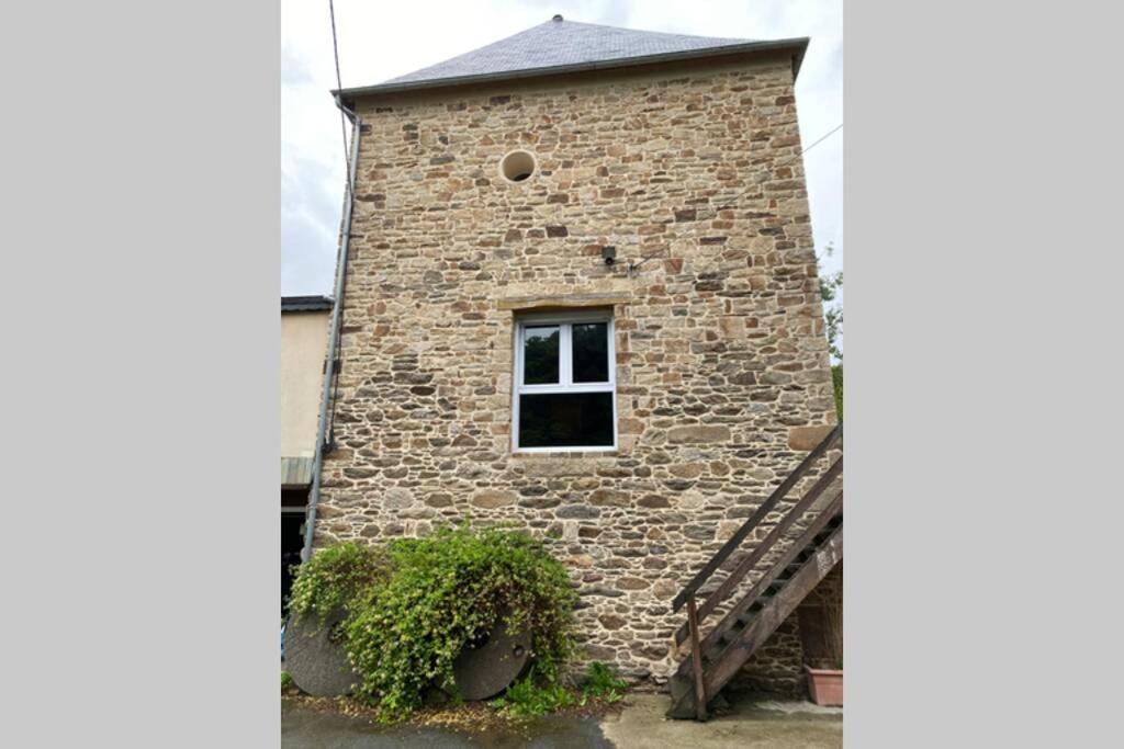 a brick building with a window and a staircase at Ancien Moulin rénové à neuf pour 20 personnes sur les rives du Trieux in Plésidy