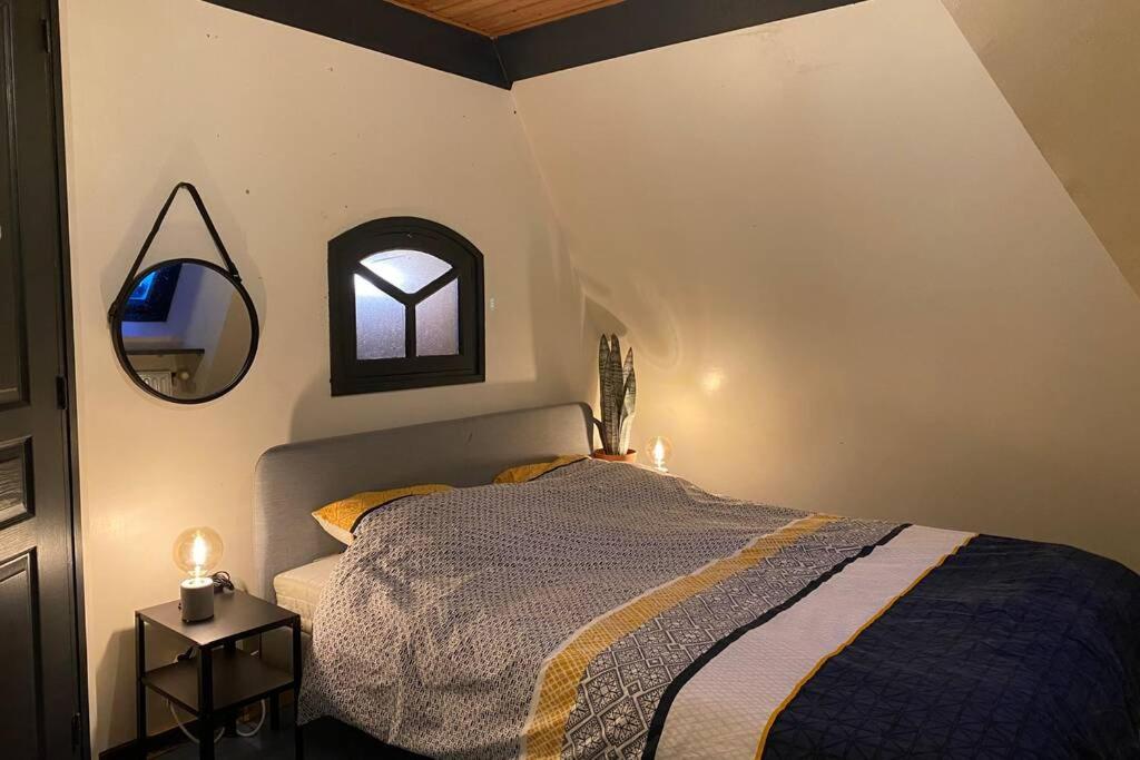 a bedroom with a bed and a mirror on the wall at Ancien Moulin rénové à neuf pour 20 personnes sur les rives du Trieux in Plésidy