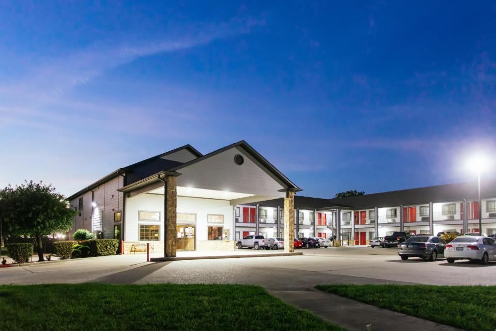 a building with a parking lot at night at Palace Inn and Suites Baytown in Baytown