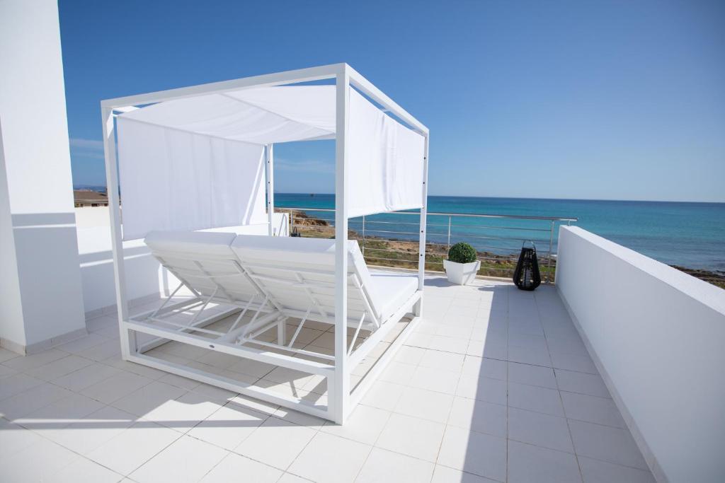 a white chair on a balcony overlooking the ocean at Son Serra Sea Coast Villa in Son Serra de Marina