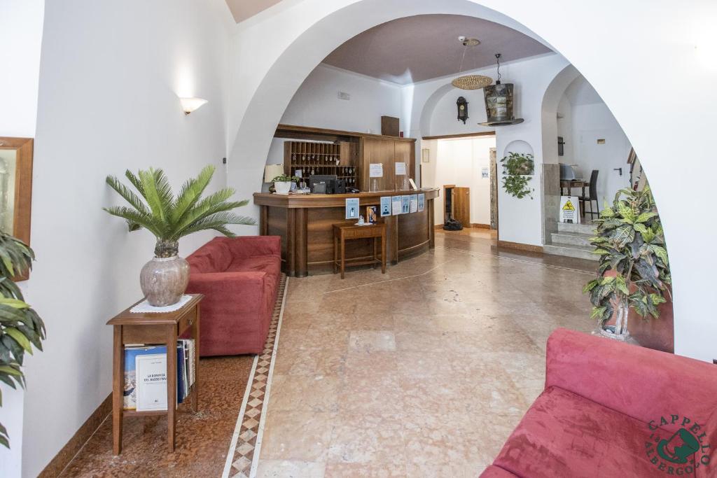 een woonkamer met 2 rode banken en een keuken bij Albergo Cappello e Cadore in Belluno