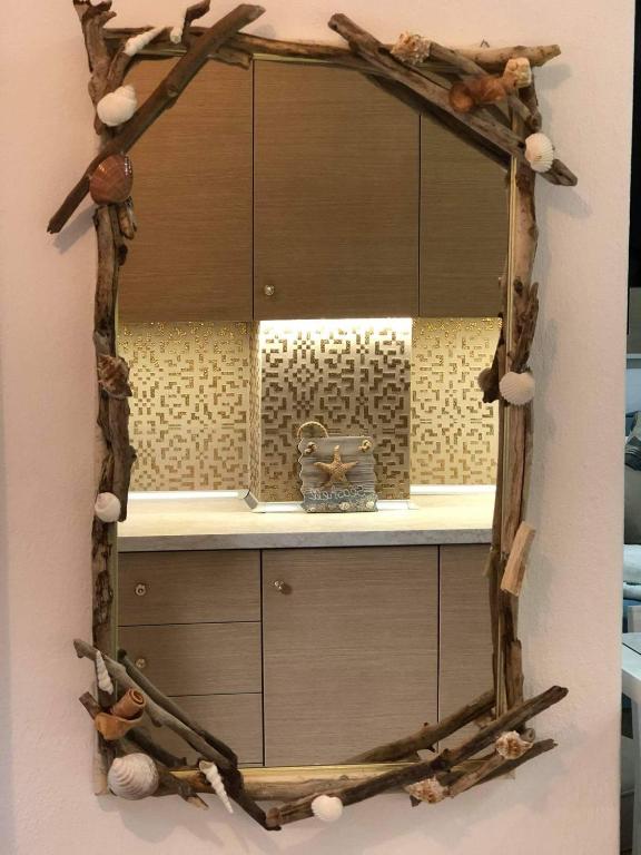 lustro wykonane z gałęzi drzew i kłód w obiekcie Seashell apartment w mieście Pefkochori