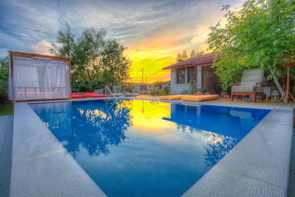 a swimming pool with a sunset in the background at Ephesus Lodge in Kirazli