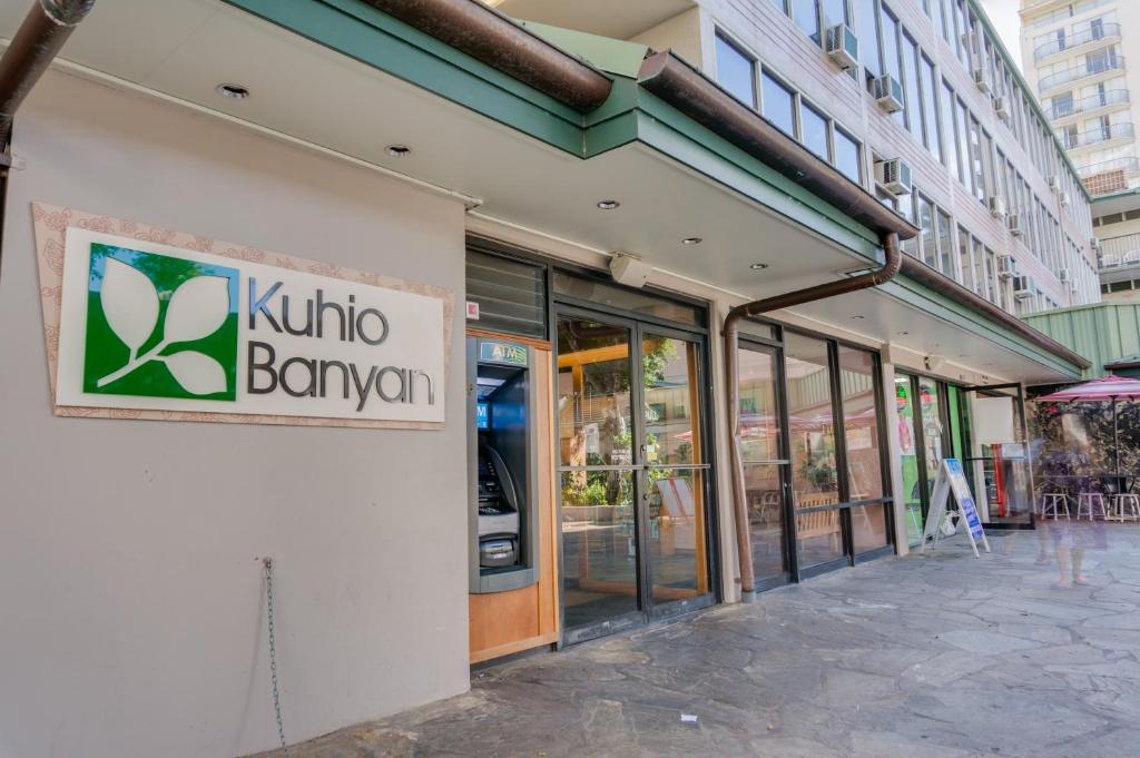 un magasin avec un panneau sur le côté d'un bâtiment dans l'établissement Kuhio Banyan Hotel (with Kitchenettes), à Honolulu