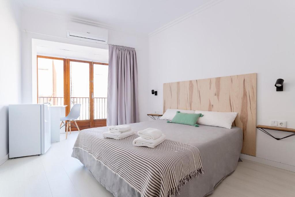 a bedroom with a large bed with two towels on it at Casa M&J GuestHouse in Alicante