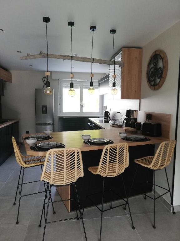 una cocina con una gran mesa de madera y sillas en La casa d'Ernestine en Colmar