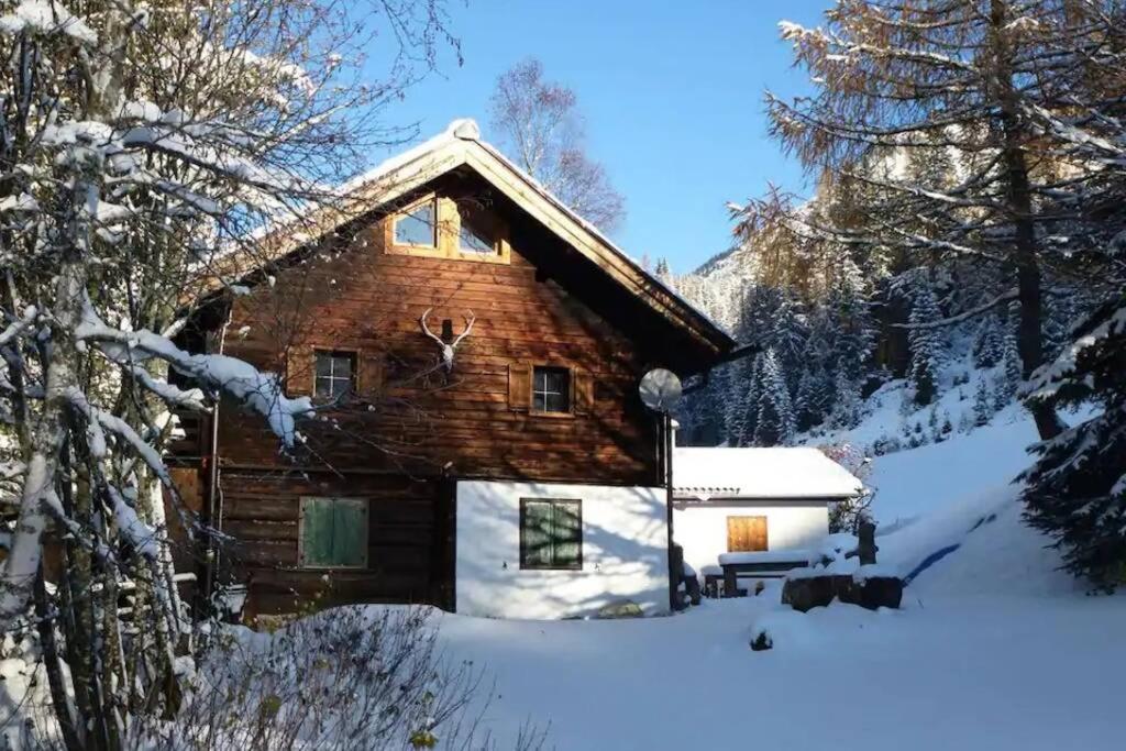 uma cabana de madeira na neve em Ski- und Sommer-Chalet für 10 Personen in Dienten am Hochkönig em Dienten am Hochkönig