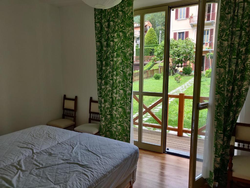 - une chambre avec un lit et une porte coulissante en verre dans l'établissement Residence Saint-Vincent, à Saint-Vincent