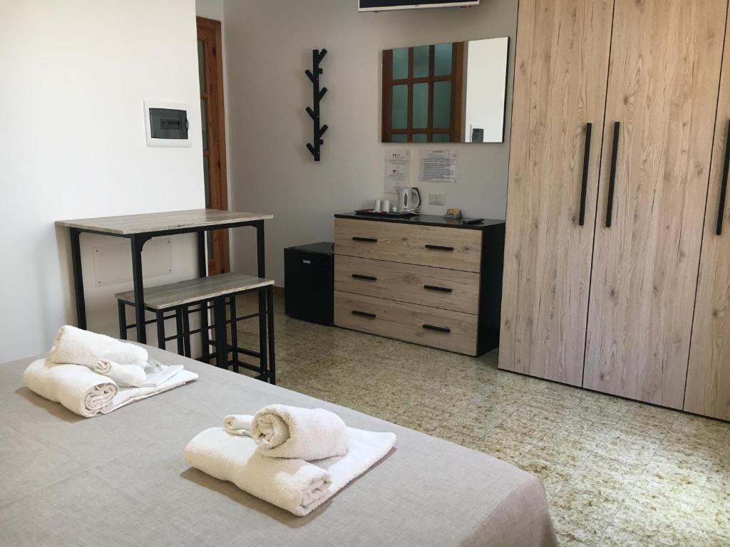 een slaapkamer met 2 bedden en handdoeken bij Mille Soli Bed and Breakfast in Buggerru