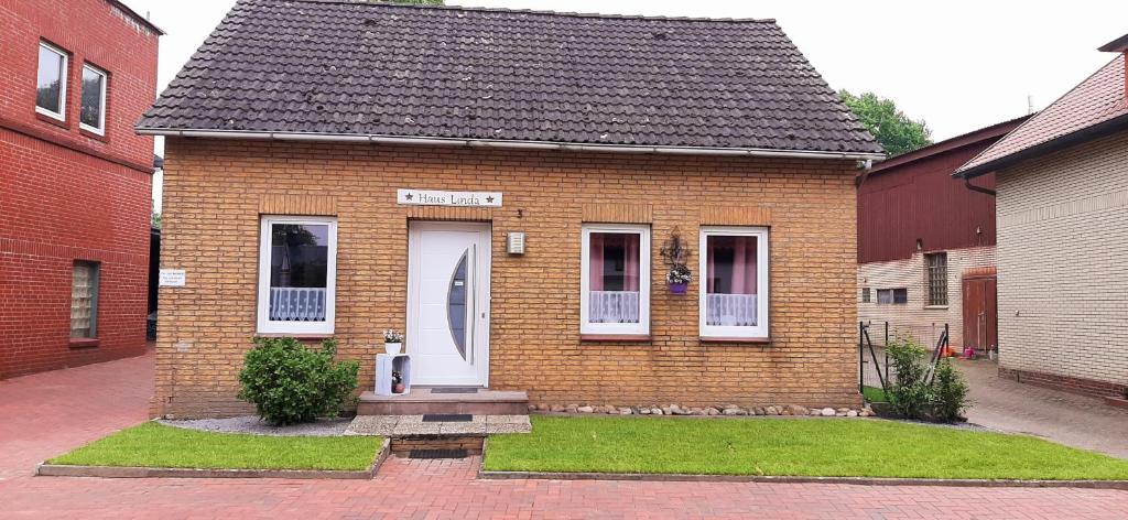 a brick house with a white door and windows at Ferienhaus Linda in Wanna