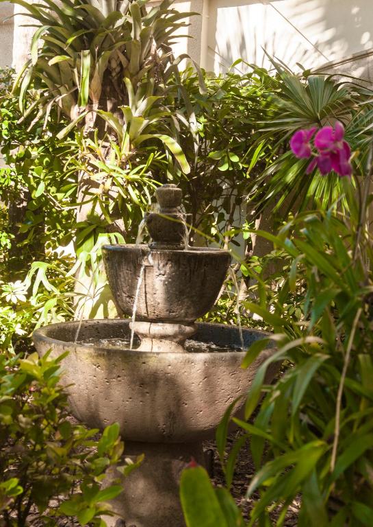a stone fountain in a garden with plants at Vanderbilt Beach Resort in Naples