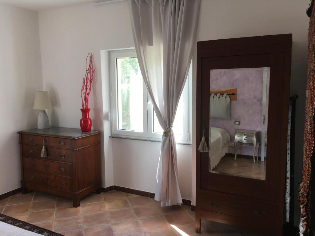 Pokój z lustrem, komodą i oknem w obiekcie A casa di Andre’ w mieście Vara Superiore