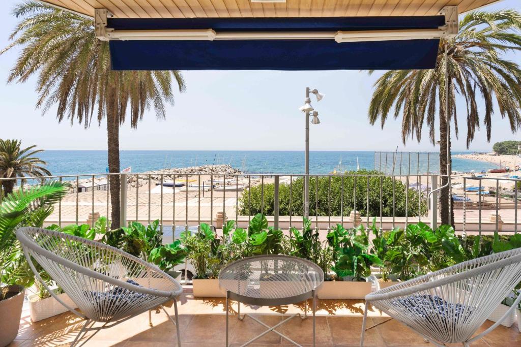 un patio con sillas y vistas a la playa en Apartamento Primera Linea de Mar con Espectaculares Vistas en San Pol de Mar