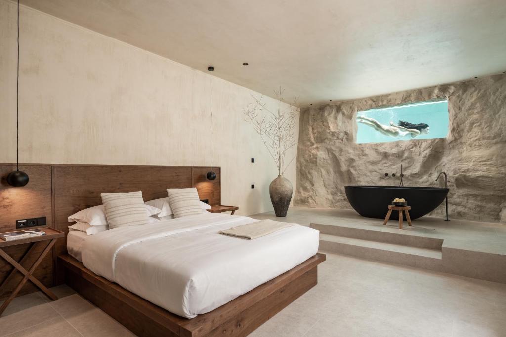 a bedroom with a large bed and a bath tub at Seven Rocks in Paliouri