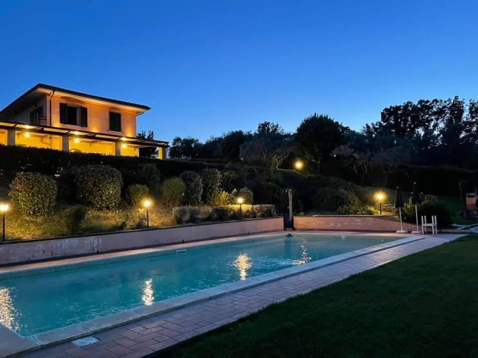 a house with a swimming pool at night at La Posta Di Bacco in Gualdo Cattaneo