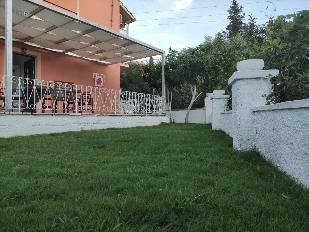 a yard in front of a house with a fence at the SummerHouse Project in Perítheia