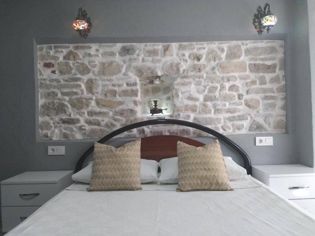 łóżko w pokoju z kamienną ścianą w obiekcie Casa Magnolia Boutique Rooms w mieście Kusadası
