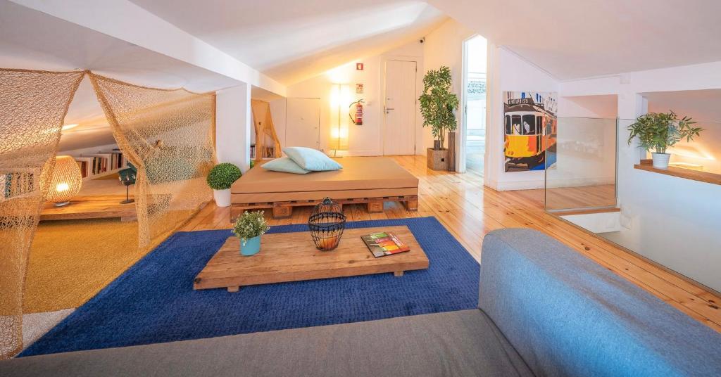 uma sala de estar com uma cama e uma mesa em We Love F Tourists em Lisboa