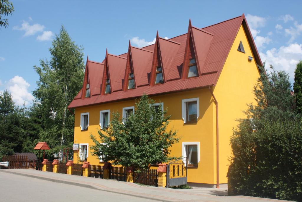 una casa amarilla y roja con techo rojo en База відпочинку "Тростян" en Slavske