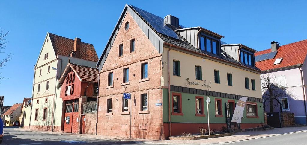 eine Reihe alter Gebäude auf einer Straße in der Unterkunft Wirtshaus & Hotel Zur Alten Brauerei Zapf in Uettingen