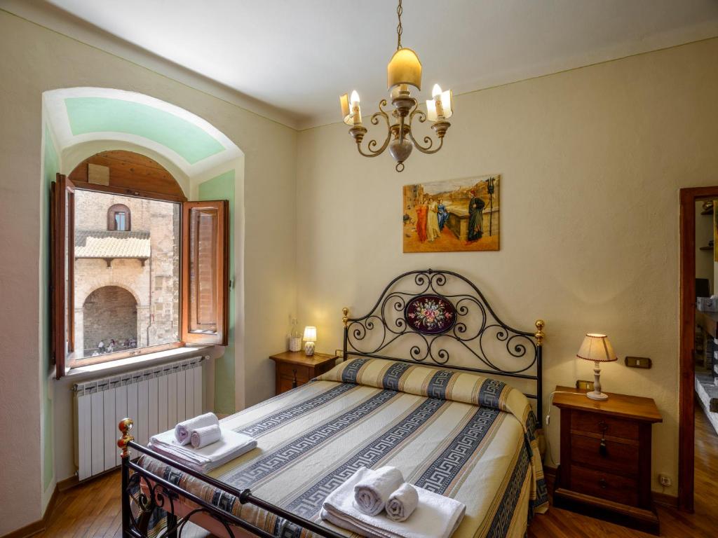 - une chambre avec un lit et un lustre dans l'établissement Sangi Studio Apartment - with amazing view of the Duomo, à San Gimignano