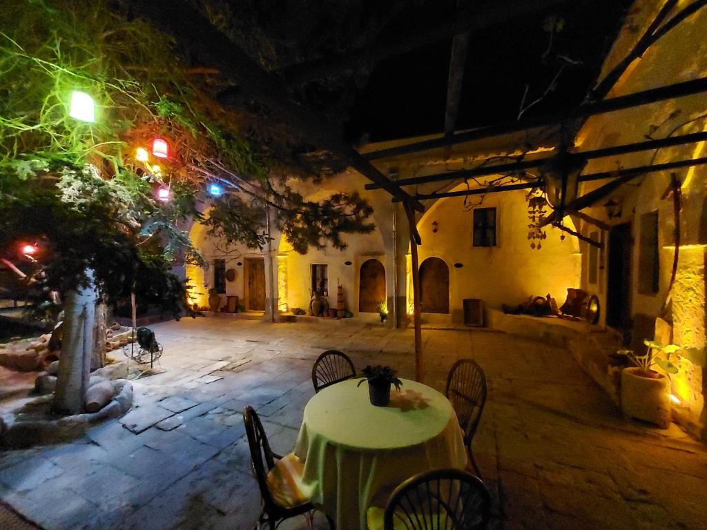 a table and chairs in a courtyard at night at ARMEsos Cave Hotel in Urgup