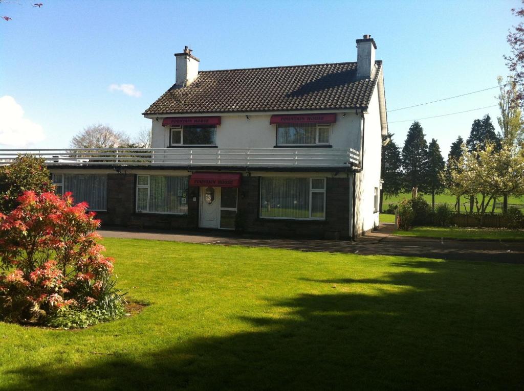 a house with a green lawn in front of it at Fountain House B&B in Macroom