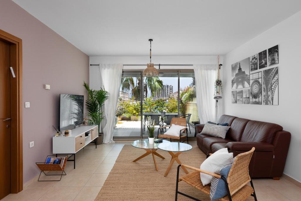 a living room with a couch and a table at Water Front Blue Lguna Garden Apartment 2bd in Herzliya B