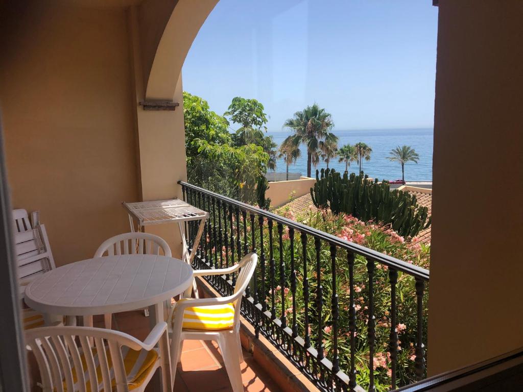 balcón con mesa, sillas y vistas al océano en Fantástico Apartamento con vistas al mar zona Club la Costa Castillo Fuengirola, en Fuengirola