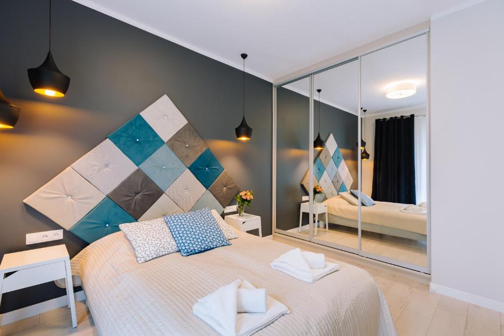 a bedroom with a bed and a large mirror at ApartmentPrestige Central Station in Krakow