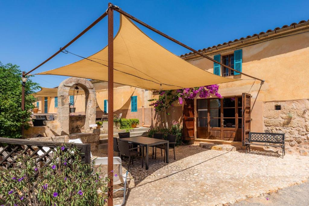 een patio met een tafel en een gele parasol bij Es Rafalet - Sa Buhardilla Petita in Manacor