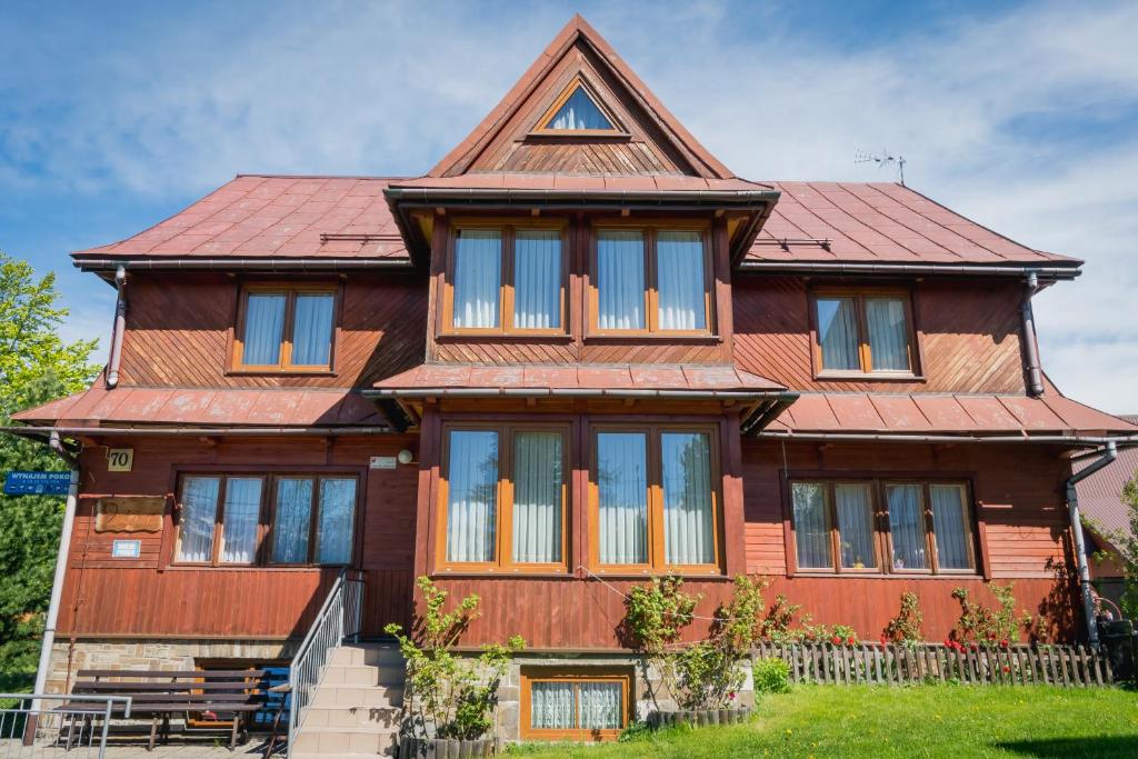 a large wooden house with a red roof at 9 Sił Drewniany Dom in Bukowina Tatrzańska