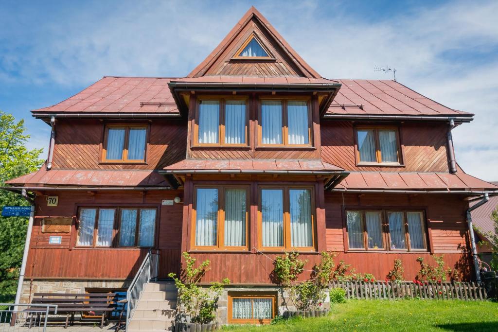 ブコビナ・タトシャンスカにある9 Sił Drewniany Domの赤い屋根の大木造家屋