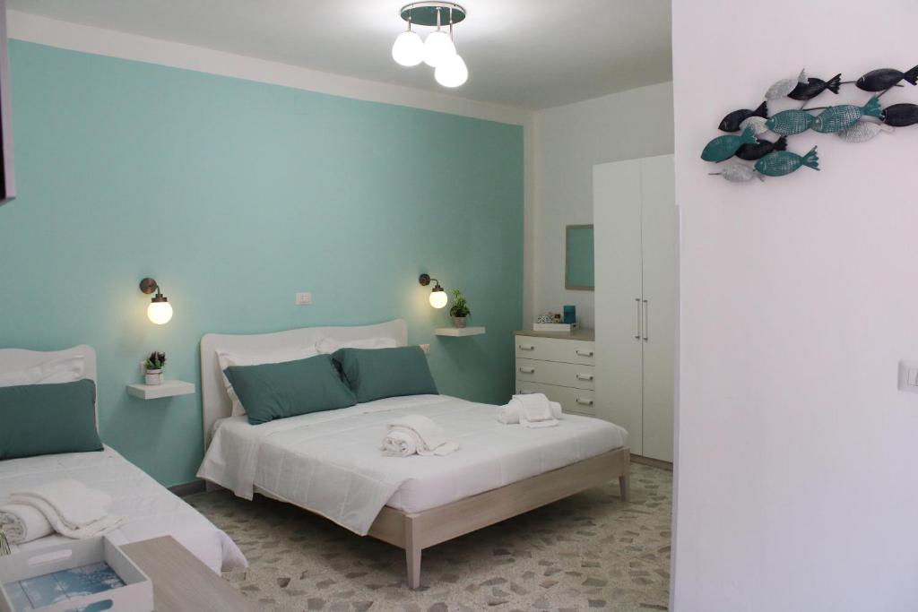 1 dormitorio con 2 camas y paredes azules en CilentoEasyRooms, en Marina di Camerota