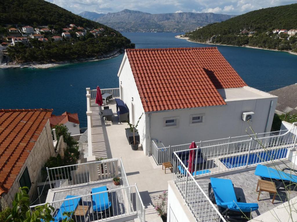 una casa con balcone arredato con sedie e acqua di Villa More a Pučišća