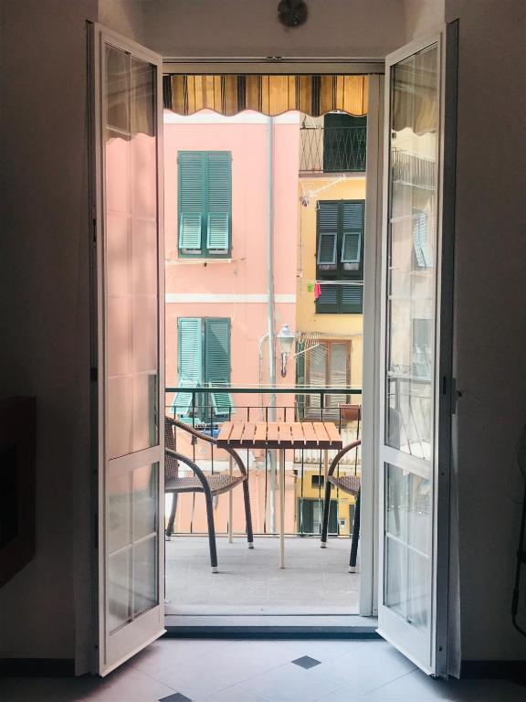 an open door to a patio with a table outside at Il Balconcino delle CinqueTerre in Vernazza