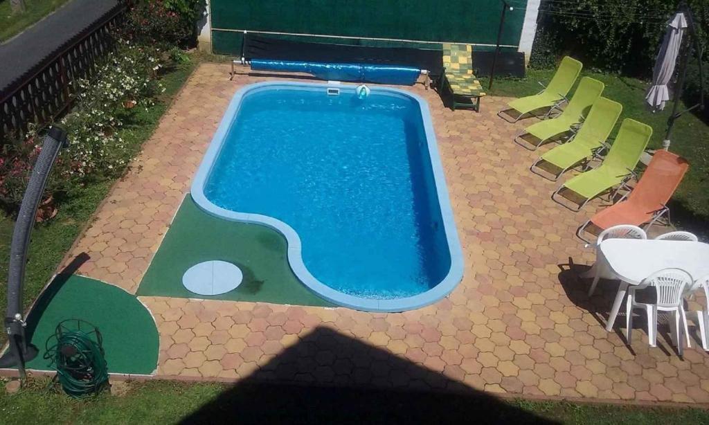 widok na basen z krzesłami i stołami w obiekcie Apartment in Balatonszarszo 20073 w mieście Balatonszárszó
