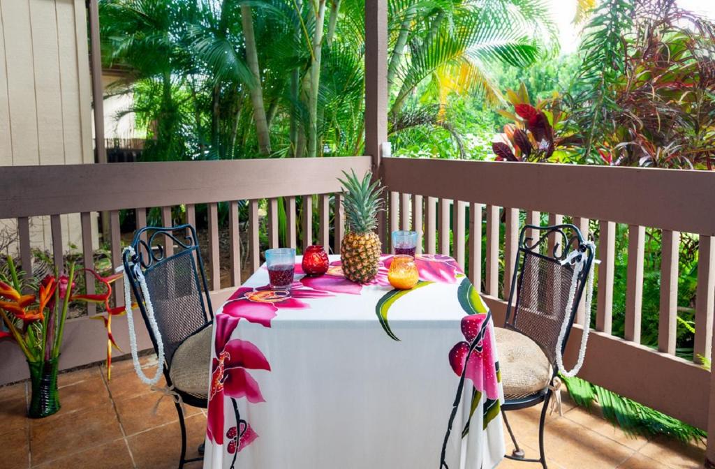 einen Tisch auf einem Balkon mit einer Ananas darauf in der Unterkunft Sandpiper 120B in Princeville